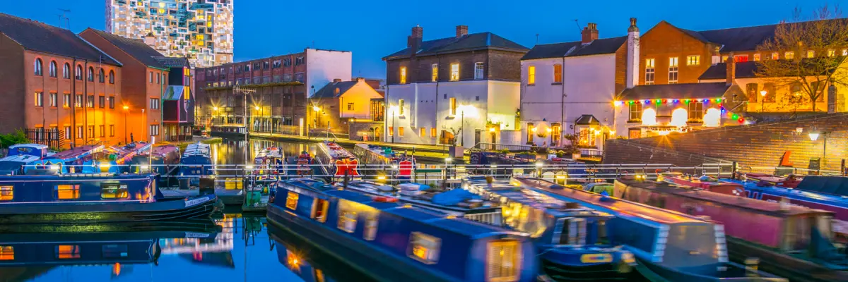 Narrow boats lit by street lighting at night.