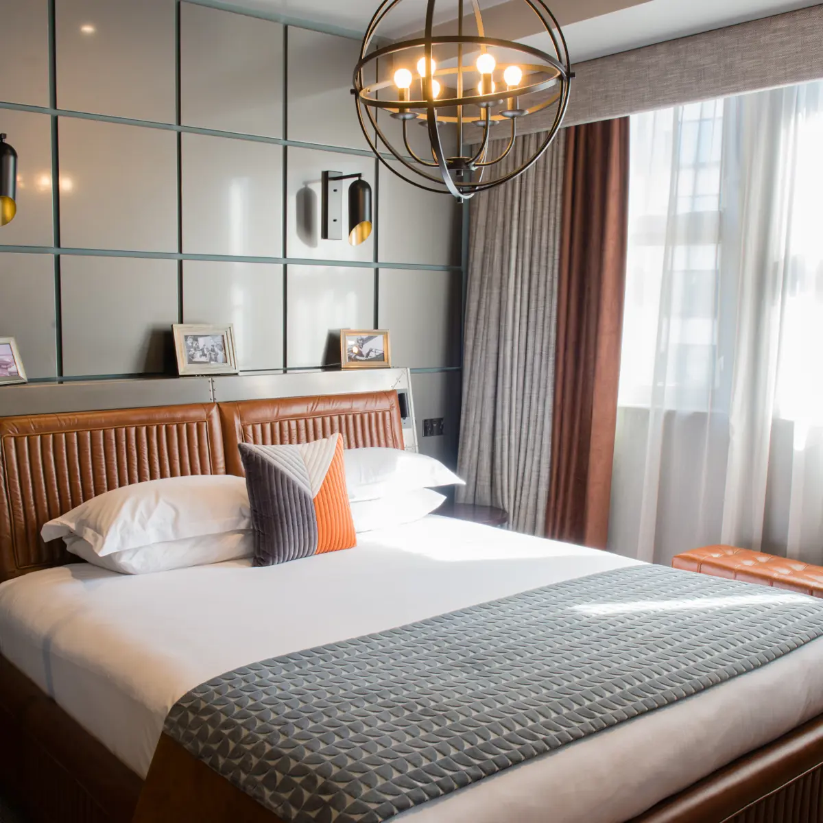 Spacious bedroom featuring a grand bed and an elegant chandelier.