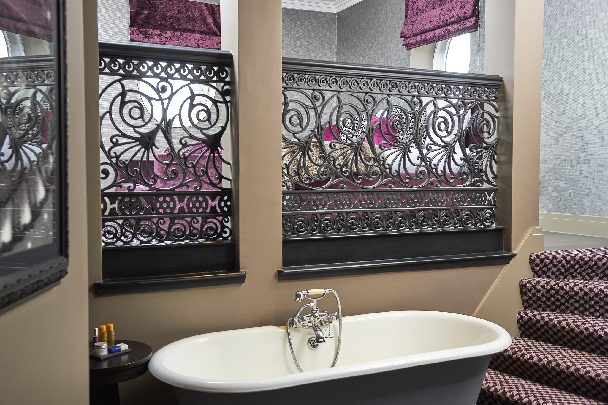 A bathtub positioned beside a bathroom window.