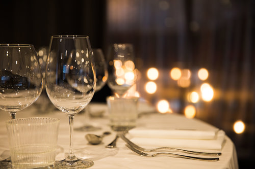 Glasses and cutlery on a white dining table