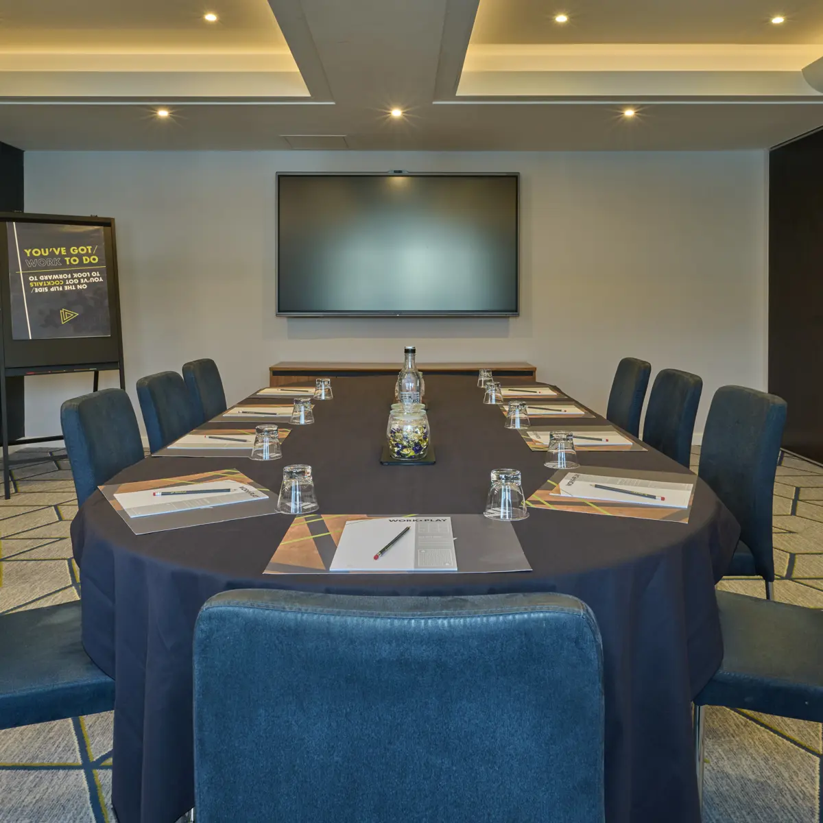 Conference room featuring tables, chairs, and a flat-screen TV.