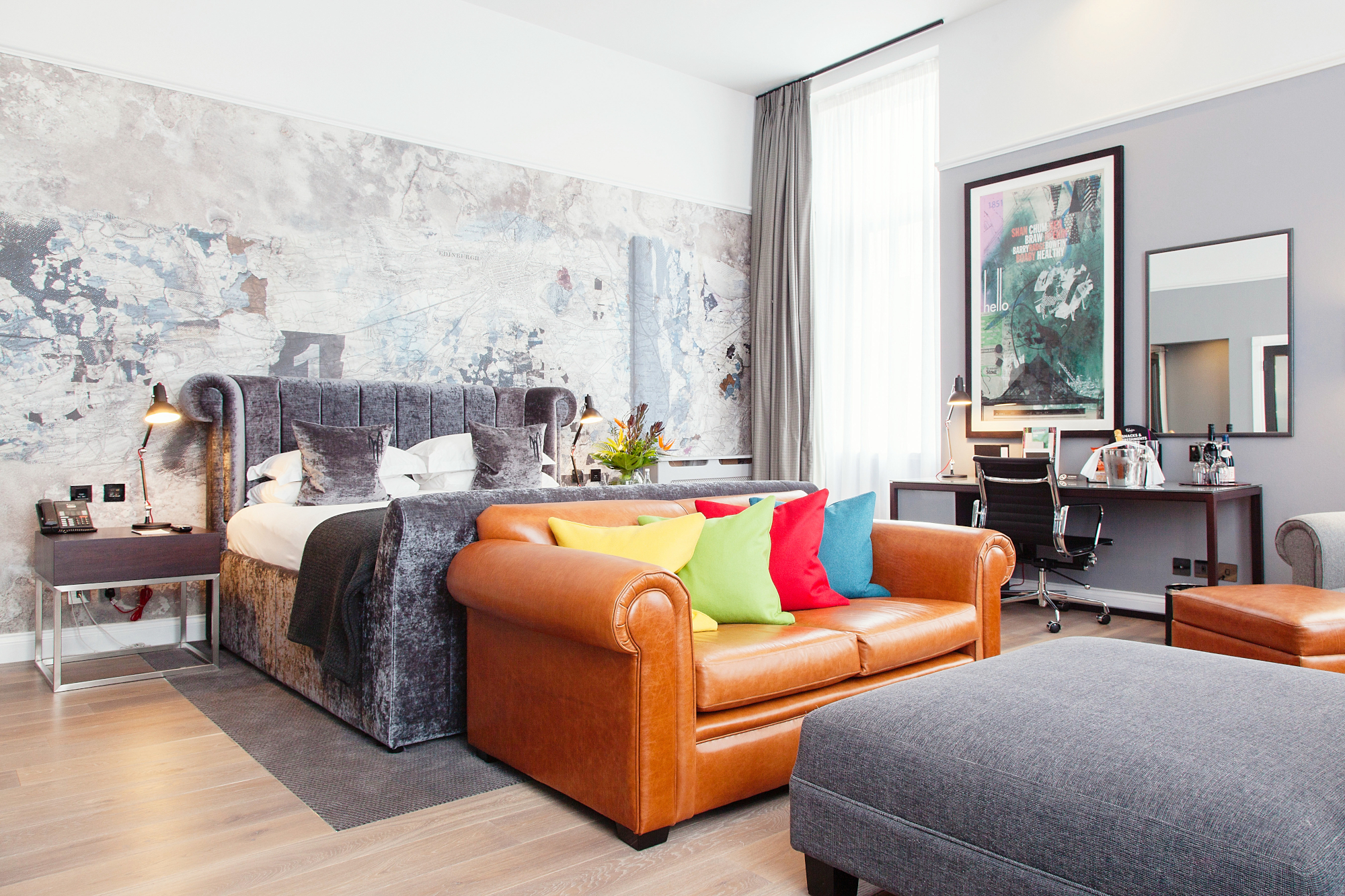 A well-furnished room featuring a brown leather sofa and a bed.